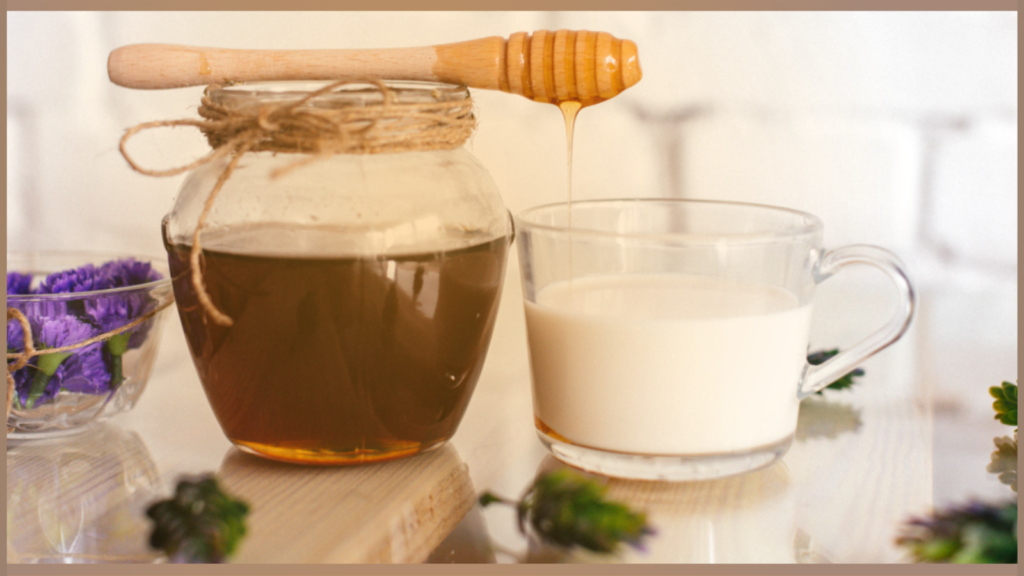 Jar of honey, glass of milk, lavender buds on the table